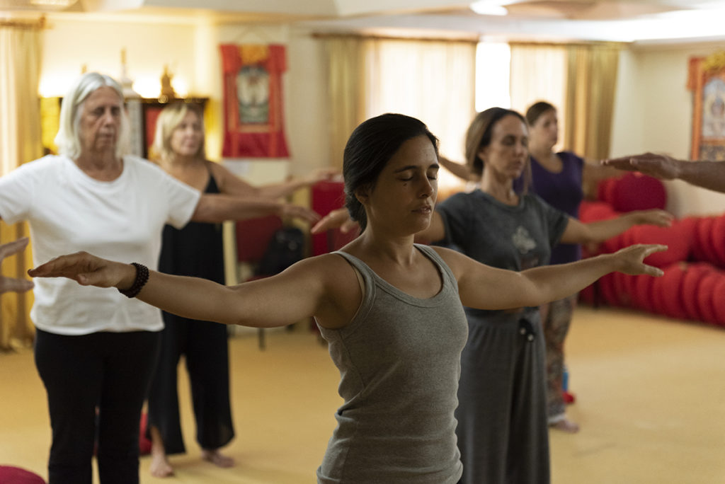 Pessoas praticando Kum Nye Yoga no salão do Centro Nyingma